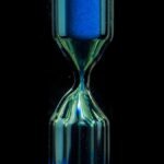 clear glass hour glass with blue liquid